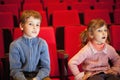 Boy and girl sitting on armchairs at cinema Royalty Free Stock Photo
