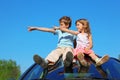 Boy and girl sitting on car roof Royalty Free Stock Photo
