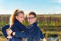 A boy with a girl are sitting on a cliff, two friends, a brother and sister are sitting in an embrace and look into the camera thr Royalty Free Stock Photo