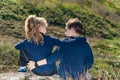 A boy with a girl are sitting on a cliff, two friends, a brother and sister are sitting in an embrace and look at each other. Royalty Free Stock Photo