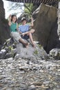 Boy and girl (10-12) sitting on rock throwing stones Royalty Free Stock Photo