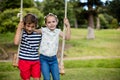 Boy and girl sitting on a swing in park Royalty Free Stock Photo