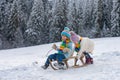 Boy and girl sledding in a snowy forest. Outdoor winter kids fun for Christmas and New Year. Children enjoying a sleigh Royalty Free Stock Photo