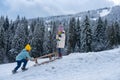 Boy and girl sledding in a snowy forest. Outdoor winter kids fun for Christmas and New Year. Children enjoying a sleigh Royalty Free Stock Photo