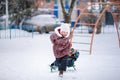 Boy and girl sledding in the snowy yard. Winter background