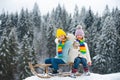 Boy and girl sledding in winter. Kids sibling riding on snow slides in winter. Son and daughter enjoy a sleigh ride