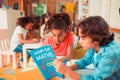 Boy and a girl solving math problems with a textbook