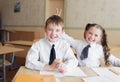 A boy and a girl students sit at a Desk in the classroom and have fun pampering Royalty Free Stock Photo