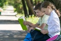 Boy and girl students reading books on the street.