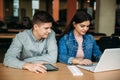 Boy and girl study in library use laptop and help each other Royalty Free Stock Photo