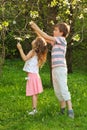 Boy and girl tear the tree flowers inside forest Royalty Free Stock Photo