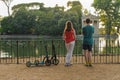 Boy and girl with their push scooters against the backdrop of the Tempio di Esculapio in the park Villa Borghese