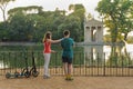 Boy and girl with their push scooters against the backdrop of the Tempio di Esculapio in the park Villa Borghese