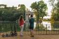 Boy and girl with their push scooters against the backdrop of the Tempio di Esculapio in the park Villa Borghese