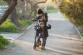 A boy and a girl are trying to ride together on a scooter Royalty Free Stock Photo