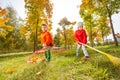 Boy and girl with two rakes working together Royalty Free Stock Photo