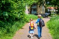 Boy and girl walking holding hands and carrying backpacks