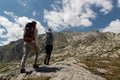 Young couple with big backpack walking to reach the top of the mountain during a sunny day