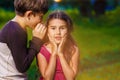 Boy girl whispers in the ear secret rumors says in Royalty Free Stock Photo