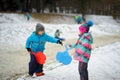 Boy and girl of younger school age in the winter park about slope for toboggans.