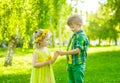 Boy gives a flower girl in the park summer day