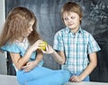 Boy gives a girl an apple at school Royalty Free Stock Photo