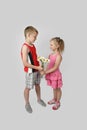 Boy gives girl bouquet of daisies on gray Royalty Free Stock Photo