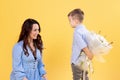 The boy gives his mother flowers and makes a surprise. A sincere mother hugs her little preschool son. March 8 Royalty Free Stock Photo