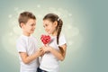 Boy gives a little girl candy red lollipop in heart shape. Valentine`s day Royalty Free Stock Photo