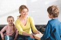 boy giving book to happy mother sitting Royalty Free Stock Photo