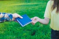 A boy giving a notebook to girl. Students holding a book