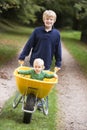 Boy giving toddler ride in wheelbarrow Royalty Free Stock Photo