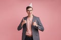 Boy in glasses in birthday cap showing thumbs up