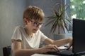 Boy in glasses enthusiastically plays computer games. Child gamer. Problems of modern youth Royalty Free Stock Photo