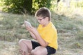 The boy in glasses looks tablet computer at nature