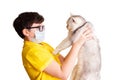 A boy in glasses and medical mask holds his white cat Royalty Free Stock Photo