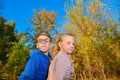 A boy with glasses next to a girl in the fall in the park, a young friendship and affection Royalty Free Stock Photo