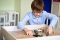 Boy glasses is sand therapy on table with light