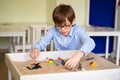 Boy glasses is sand therapy on table with light