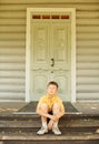 Boy in glasses seat on doorstep Royalty Free Stock Photo