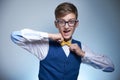 Boy with glasses and a shirt straightens a bow tie