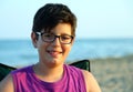 Boy with glasses smiling on the sea shore Royalty Free Stock Photo