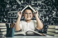 A boy with glasses studied and put a book on his head in the classroom Royalty Free Stock Photo