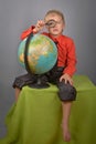 The boy with the globe and a magnifier. Royalty Free Stock Photo
