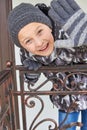 Boy in gloves is welcome,young boy on the stairs smiling and waving his arms in winter