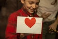 Boy glues to window envelope with valentine for his girlfriend. Preparing surprise for her. Authentic view through window