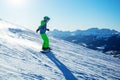 Side profile view of snowboarder boy go downhill in the mountain