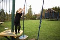 The boy goes through an obstacle course is engaged in active sports to hold on to the rope and wants to move with the help of her