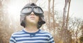 Boy with goggles against blurry trees with flare