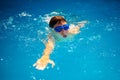 BOY WITH GOGGLES EXERCISING FREESTYLE SWIMMING AND BREATHING Royalty Free Stock Photo